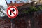 The traffic sign prohibits turning right at the old brick wall.