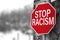 Traffic sign with `Stop racism` message. Selective focus.