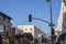 A traffic signal with 4 lights with the red light on at Green street surrounded by office buildings and shops