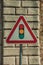 Traffic signal ahead road sign in front of stone brick wall