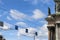 Traffic signals on wires on a blue sky and statue facade