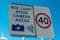 Traffic signs warning for speed limits 40 km/h and Red light speed camera ahead.