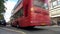 Traffic, taxis and red double decker London buses driving past Selfridges, Oxford Street, London, England