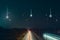 Traffic trails at night on a motorway going across the countryside. As UFO`s fall from the sky