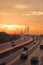 Traffic on a wide freeway against the backdrop of a sunset and a smoking power plant, July 2021