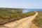 Trail, beach, mountains and vegetation in Arrifana