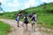 On the trail, female tourists climb to the Serrote stone