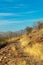 Trail or foot path in the hills of Arizona with natural foliage and grass and distant moutains on sunny cloudless day