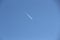 A trail of a jet in the blue sky / A high-flying aircraft in the sky /