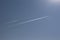 A trail of a jet in the blue sky / A high-flying aircraft in the sky /