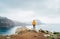 Trail runner man dressed orange waterproof jacket, running tights and shoes enjoying Atlantic ocean bay view on Ponta de Sao