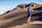 Trail runner man running with backpack on volcano mountain. Ultra marathon race athlete on volcanic path run in mountains