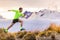 Trail runner man running on New Zealand mountains nature. Sport athlete jumping over hills with Mount Cook at dusk landscape