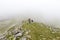 Trail runners in a mountain race and tourists hiking on Retezat mountain