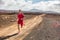 Trail running athlete fitness man runner sprinting on desert dirt road wearing compression clothes and wearable tech smartwatch