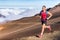 Trail running runner man on endurance run with backpack on volcano mountain. Ultra marathon race athlete on volcanic rocks path in