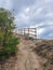 Trail with a wooden railing, footpath, country road, alley, lane in Bulgarian forest and the sky as background.