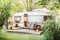 trailer design home. Wooden RV house porch with garden furniture. Campsite in garden.