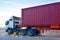 Trailer truck loaded with forty feet container under quay crane.