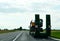 Trailer truck with long platform transport the Excavator on highway. Logistics of transportation of heavy and oversized cargo by