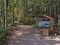 Trailhead of Grassi Lakes Trail in forest near Canmore in the Canadian Rocky Mountains with information sign and trail map.