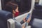 Train commute during corona virus pandemic. Woman passenger using mobile phone wearing face mask sitting in public