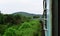 Train crossing meadows in a hilly railroad with a motion blur