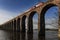 Train Crossing Stone Viaduct Over River