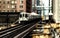 Train on elevated tracks within buildings at the Loop, Glass and Steel bridge between buildings - Chicago City Center - Sepia Glow