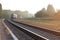 Train leaving the station on foggy morning. Industrial landscape