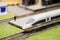 Train model and railroad tracks with scenery. White electric train locomotive model and station platform