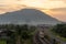 A train move from train station. Background is hill.