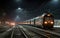 The train is parked at the train station at night