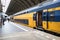 Train at a platform inside a railway station with doors open prior to departure