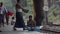 TRAIN PLATFORM: Passengers sit and walk platform, guy dumps bucket of liquid