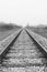 Train rails, black and white image of railway. Vertical image of railroad.