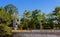 Train signals and trees above bridge with fence