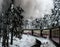 Train in the snowy forest over bridge