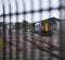 Train at station behind railings