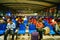 Train station passenger waiting area, rows of chairs and a number of male and female passengers