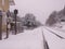 Train station with rail track covered by snow.