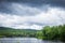 A train track crossing over a New Hampshire river on bright cloudy blue day