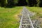 Train track disappearing into the horizon in lush green field