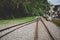 Train tracks on gravel, two of railways tracks merge in a rural scene background, concept of journey