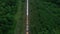 The train transports tanks of crude oil among virgin ecological green forests. Aerial view.