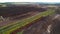 Train transports to peat in freight wagons from peat extraction. Peat extraction site. Harvester at collecting peat on peatlands