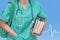 Trainee surgeon in a blue uniform with books and a bag on blue background electrocardiogram. Medical doctor over blue health care