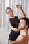 Trainer Assisting Ballet Dancer In Rehearsal Room