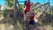 Trainer assisting a school girl in rope climbing during obstacle course 4k