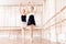 The trainer of the ballet school helps young ballerina perform different choreographic exercises.